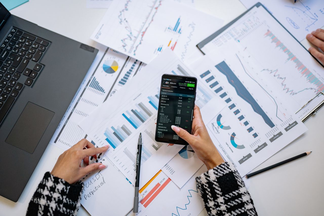 Vue d’ensemble sur des graphiques et un smartphone dans un bureau, illustrant l’analyse de données.
